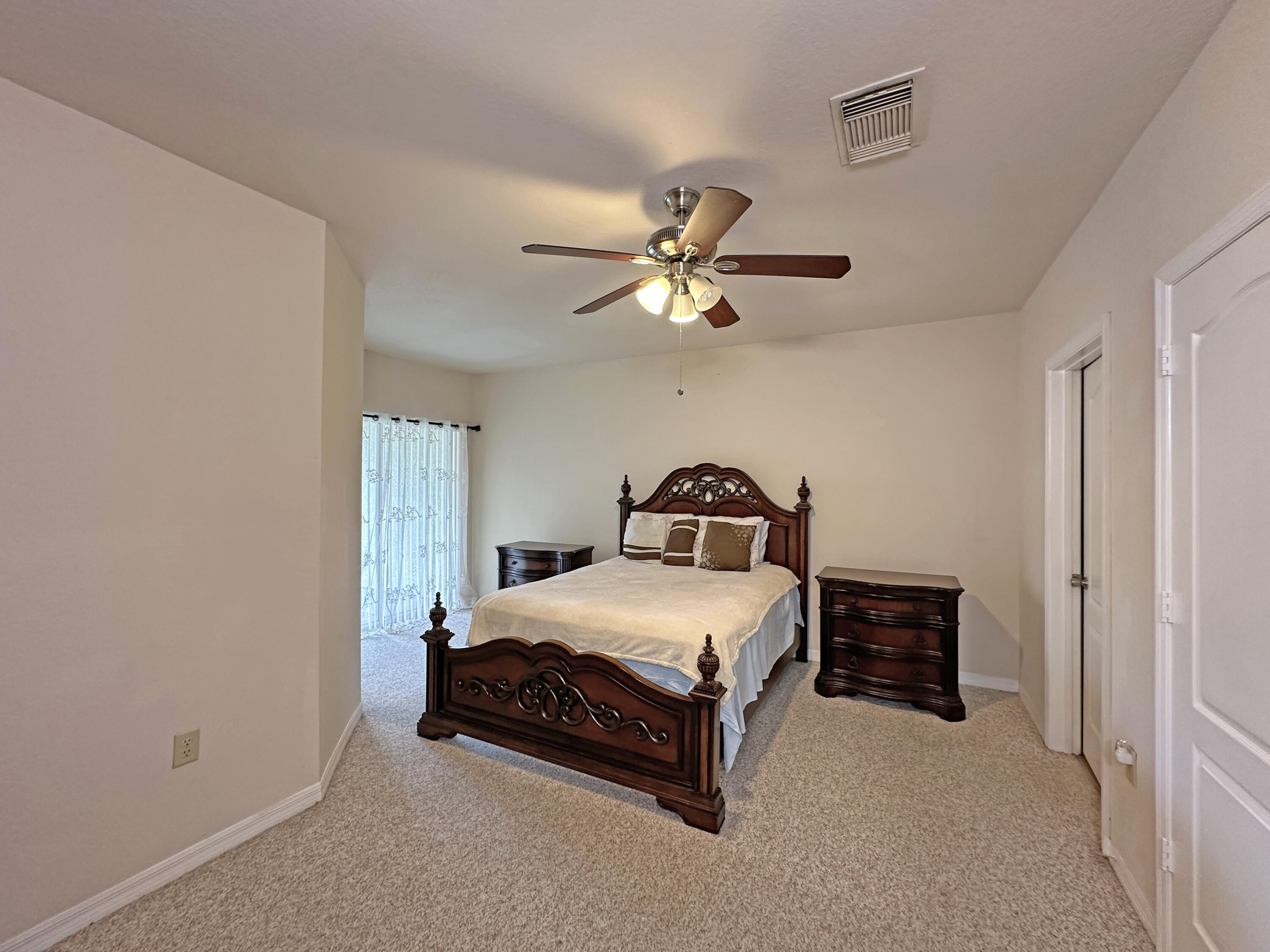166 Southwest Peacock Boulevard, Unit 34202 Port St. Lucie, FL 34986 - Photo 18 of 56 a bedroom with a bed and a ceiling fan