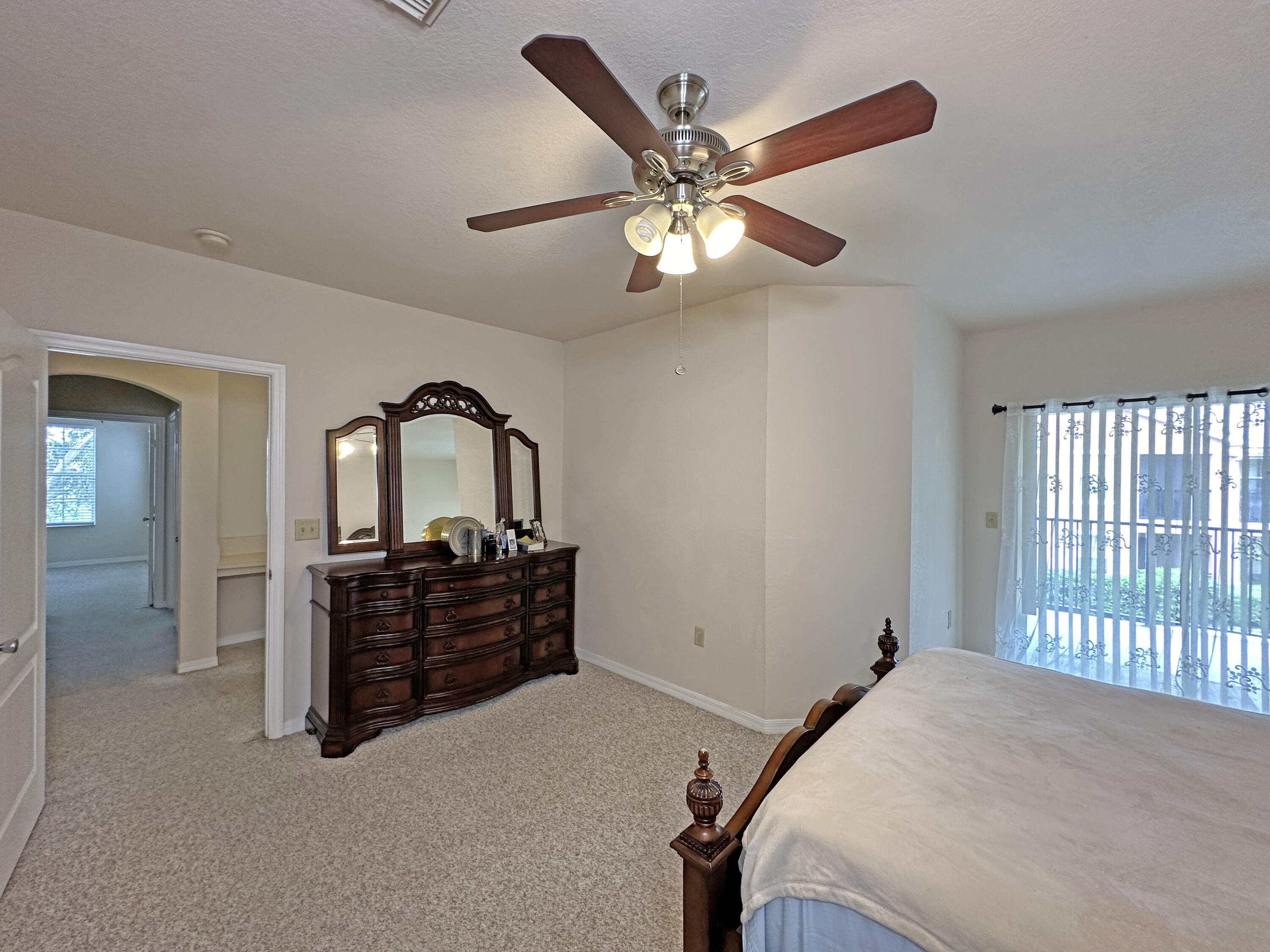 166 Southwest Peacock Boulevard, Unit 34202 Port St. Lucie, FL 34986 - Photo 21 of 56 a bedroom with a bed and a chandelier