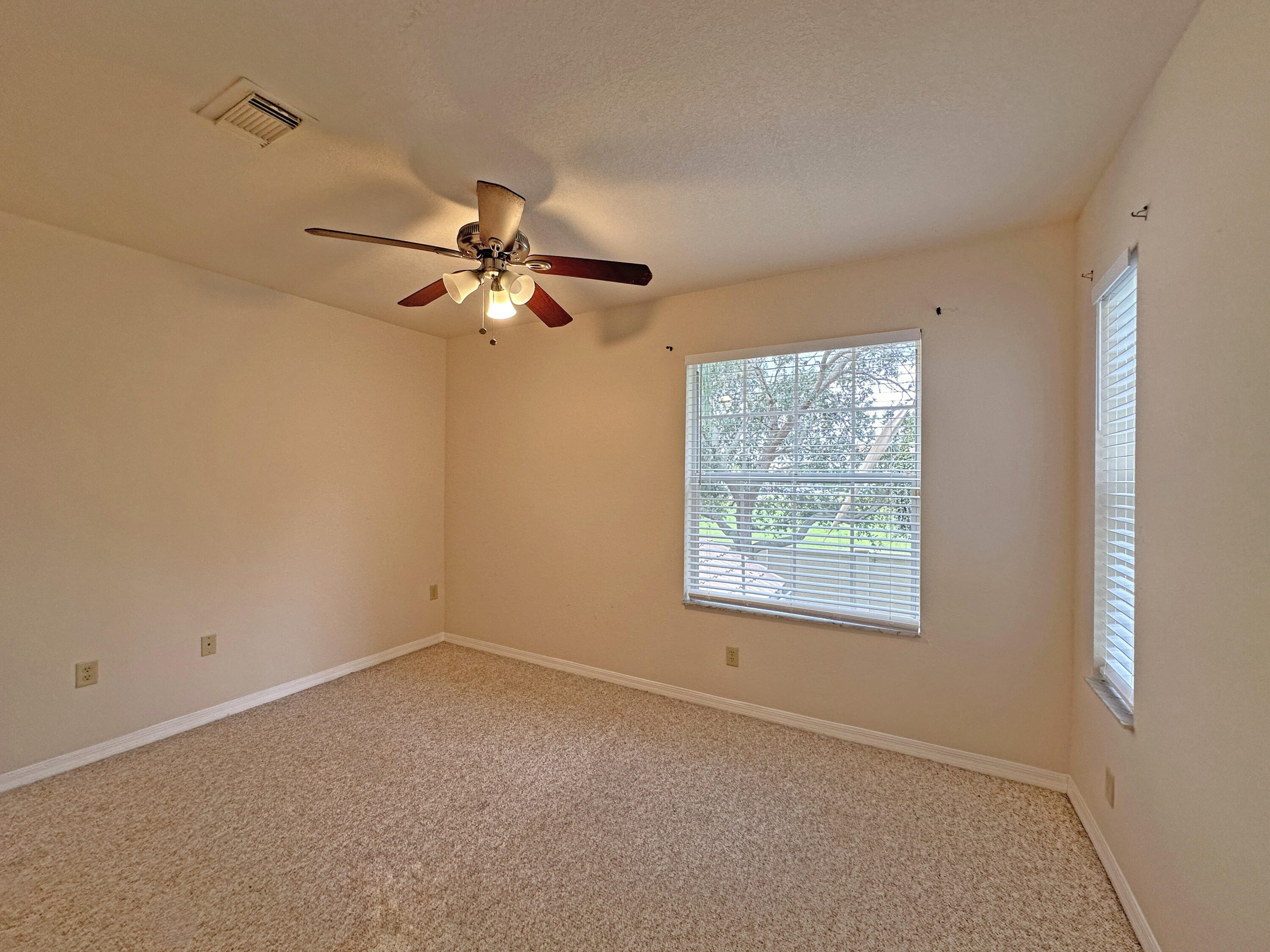 166 Southwest Peacock Boulevard, Unit 34202 Port St. Lucie, FL 34986 - Photo 28 of 56 an empty room with a window and a fan