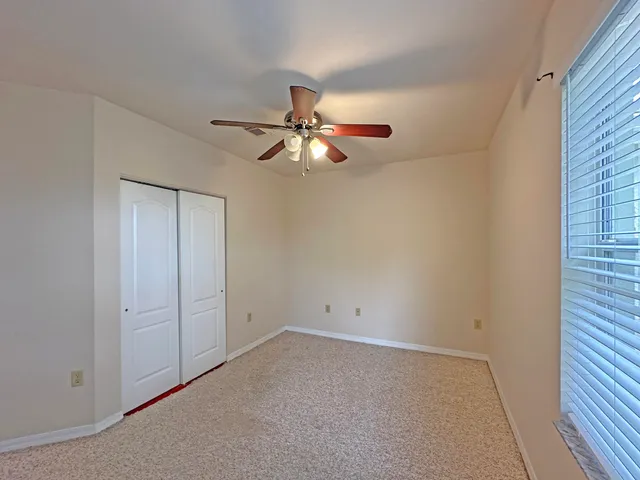 a view of an empty room with a ceiling fan