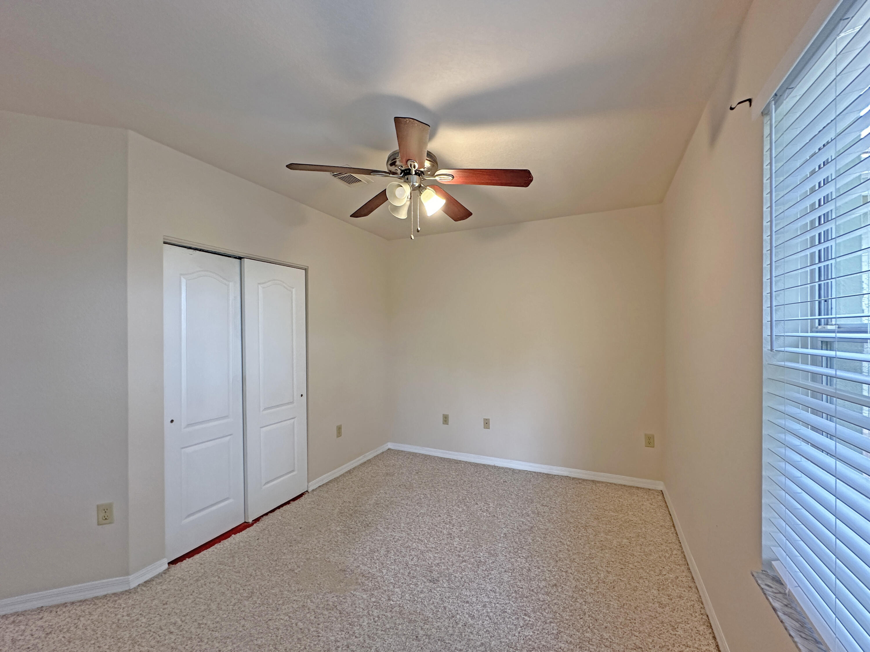 166 Southwest Peacock Boulevard, Unit 34202 Port St. Lucie, FL 34986 - Photo 29 of 56 an empty room with closet and a chandelier fan