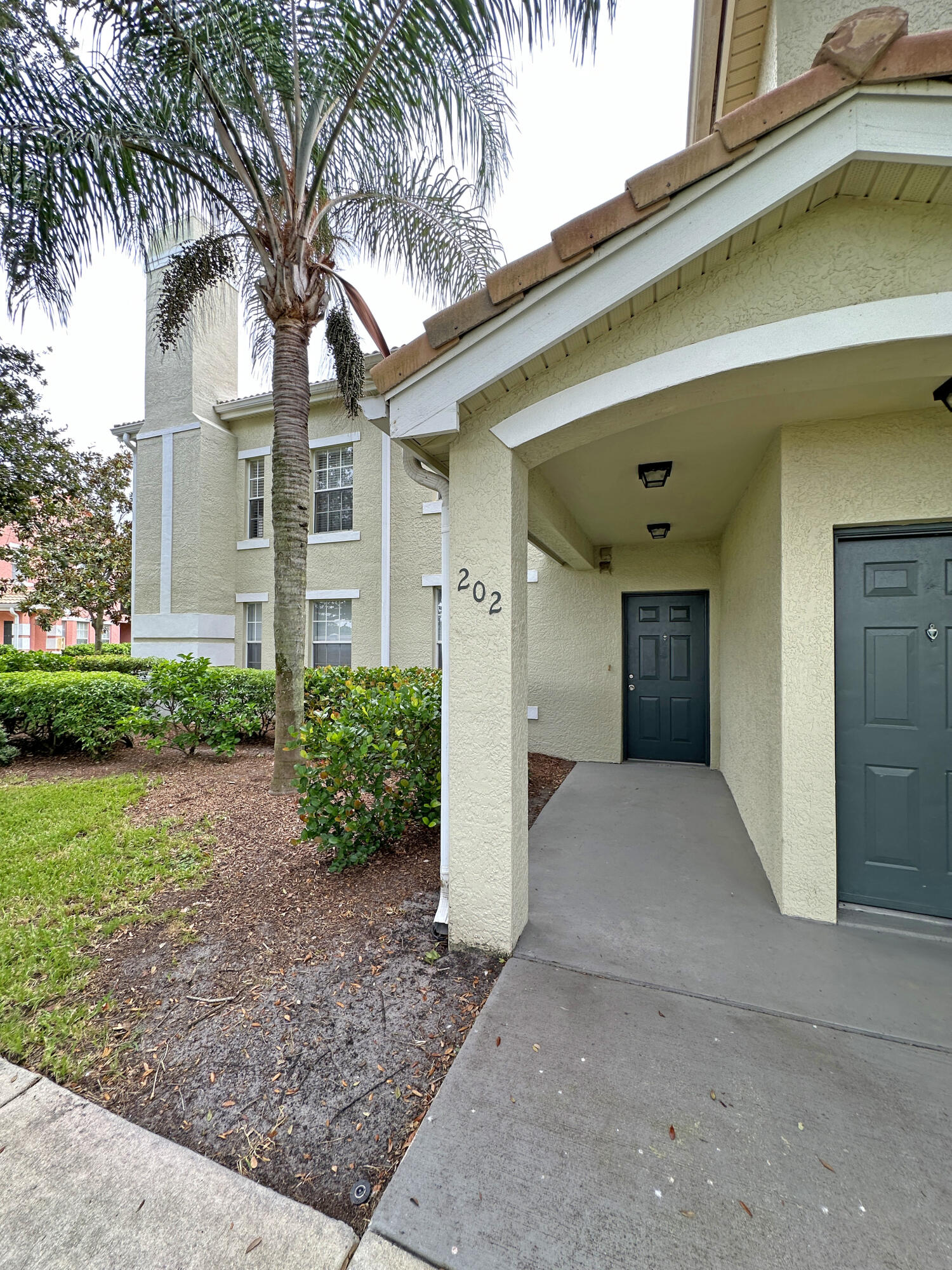 166 Southwest Peacock Boulevard, Unit 34202 Port St. Lucie, FL 34986 - Photo 4 of 56 a front view of a house with garden