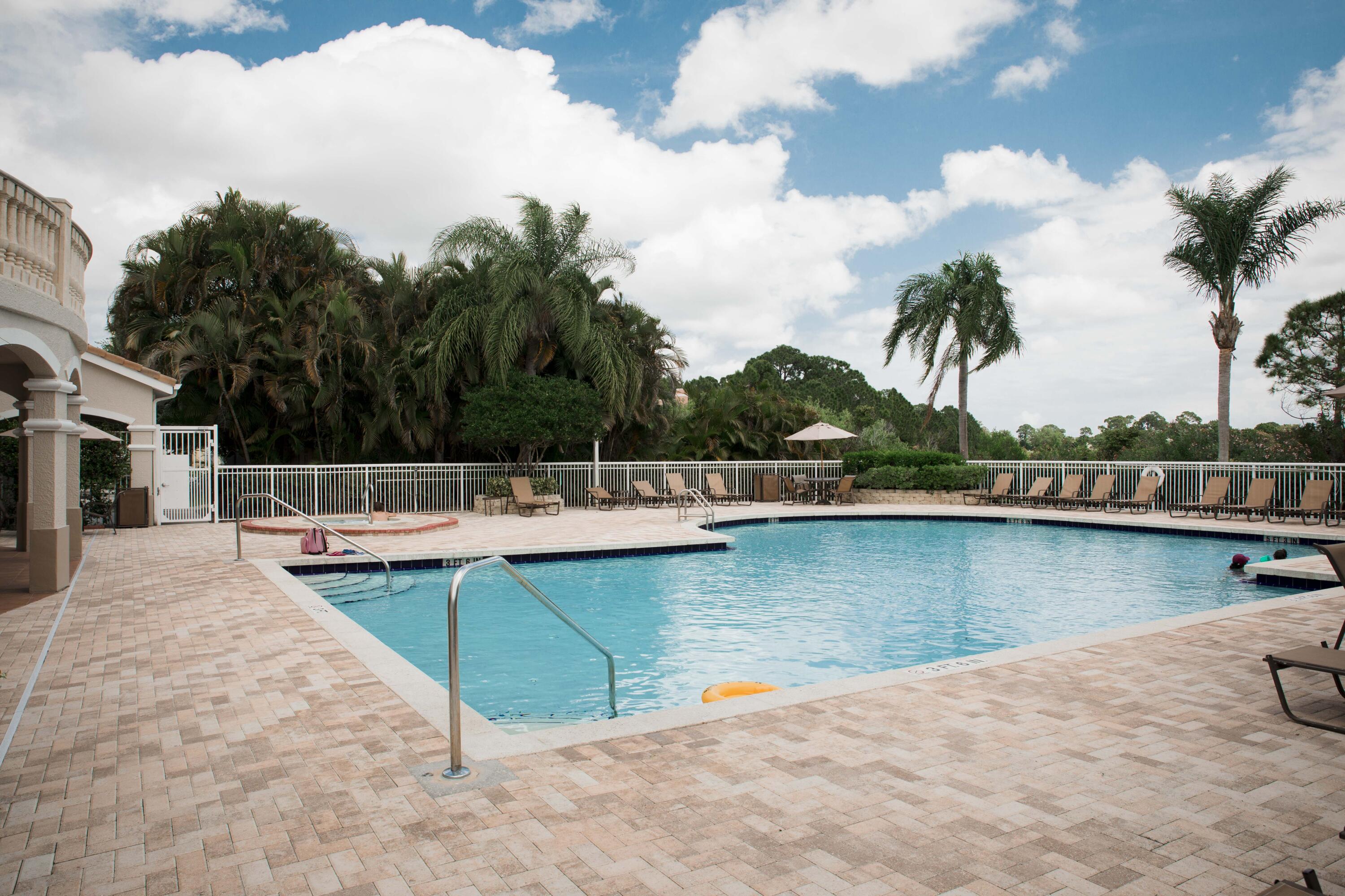 166 Southwest Peacock Boulevard, Unit 34202 Port St. Lucie, FL 34986 - Photo 49 of 56 a view of a swimming pool with lounge chairs