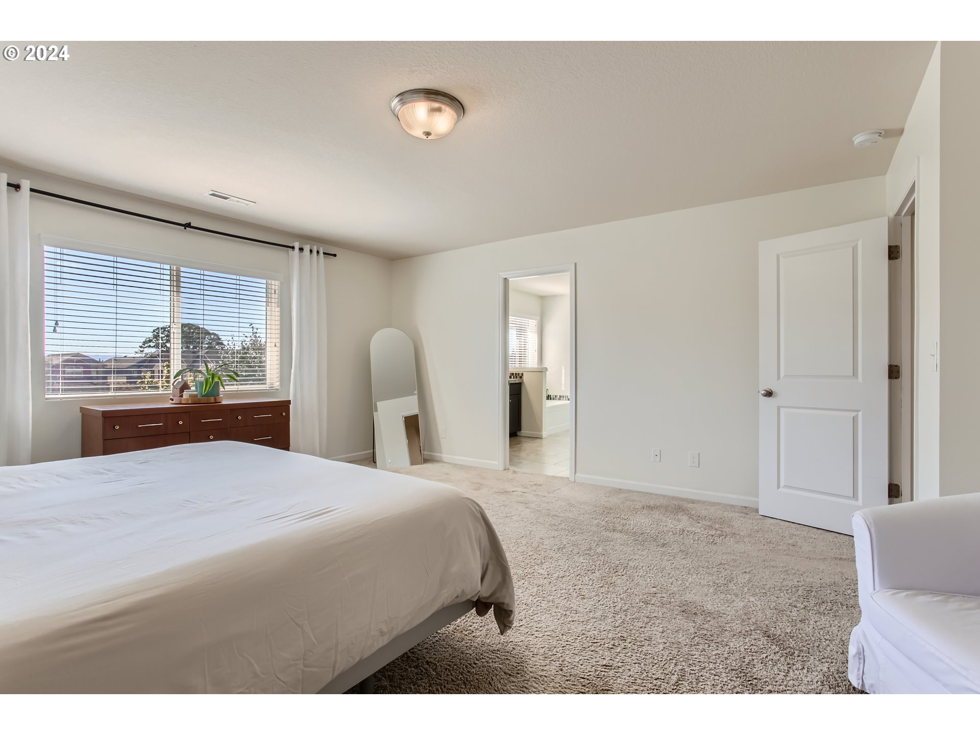 263 North 34th Court Ridgefield, WA 98642 - Photo 18 of 40 a bedroom with a bed and a large window
