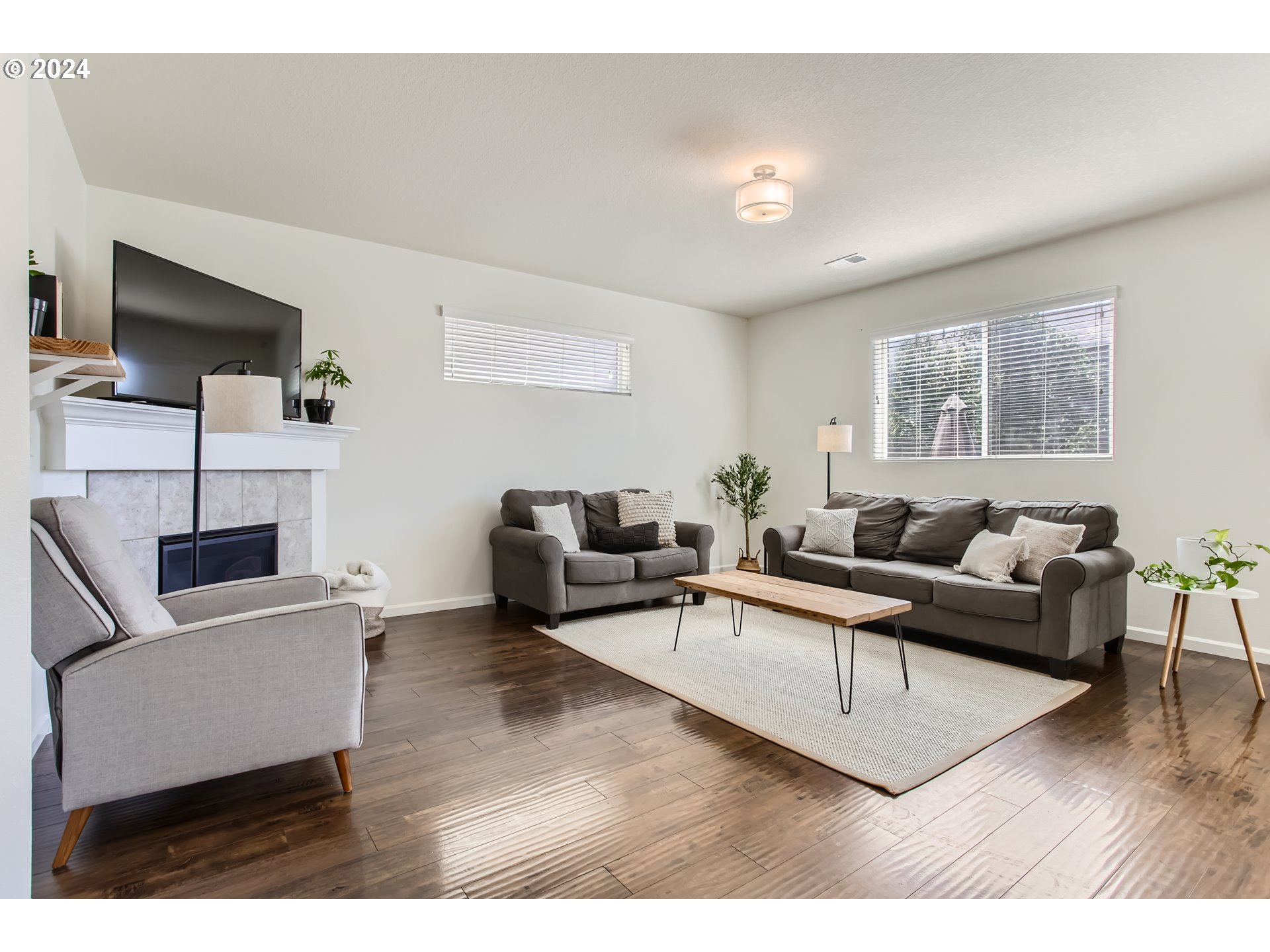 263 North 34th Court Ridgefield, WA 98642 - Photo 5 of 40 a living room with furniture a flat screen tv and a wooden floor