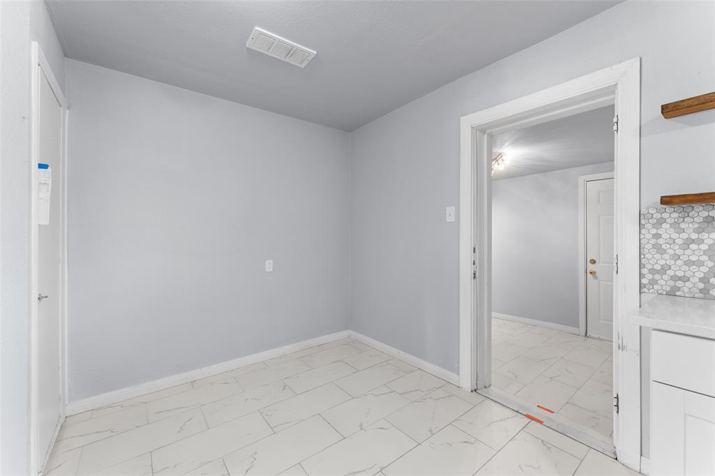 612 East 8th Street Kemp, TX 75143 - Photo 13 of 25 Modern room featuring light gray walls, white trim, and large format white tile flooring with subtle veining