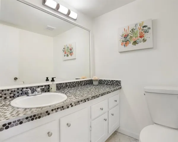 a bathroom with a granite countertop sink and a mirror