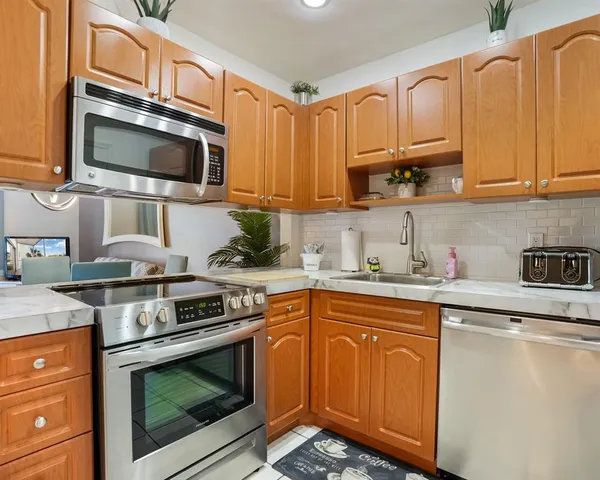 a kitchen with stainless steel appliances granite countertop a stove microwave and sink