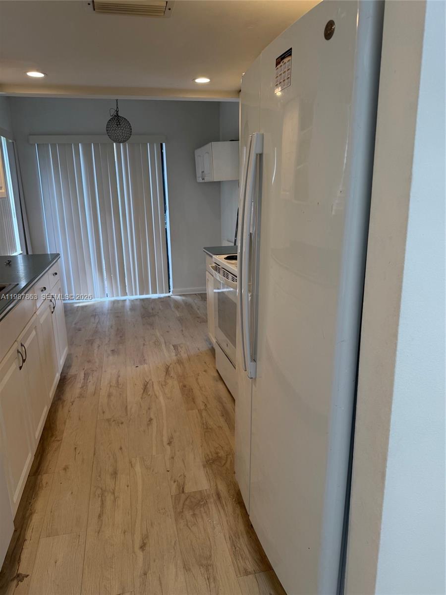 1419 Yellowthroat Street Homestead, FL 33035 - Photo 13 of 26 a view of a refrigerator in kitchen and wooden floor