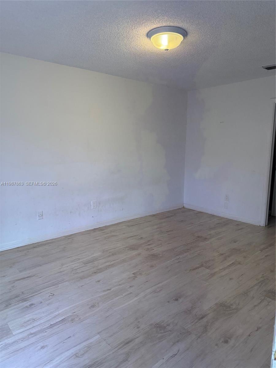 1419 Yellowthroat Street Homestead, FL 33035 - Photo 14 of 26 an empty room with wooden floor and windows
