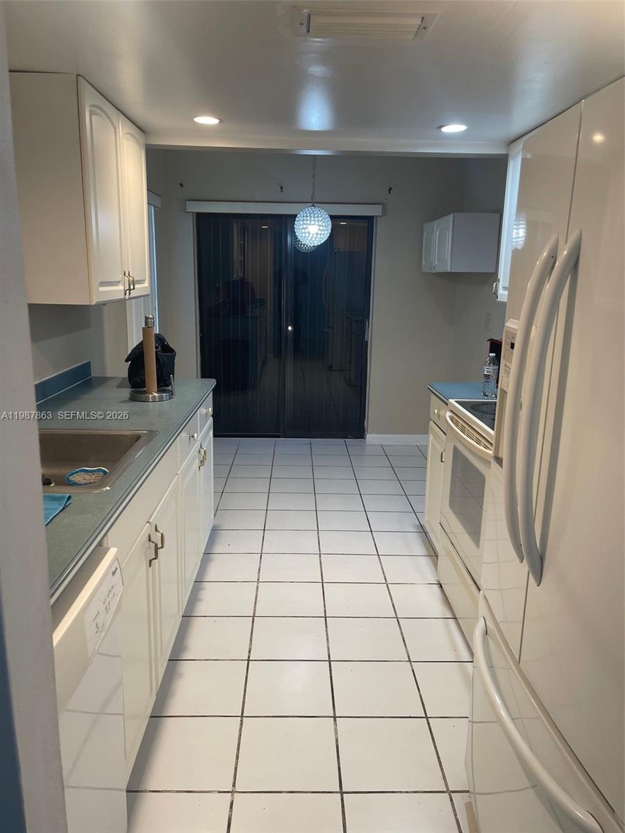1419 Yellowthroat Street Homestead, FL 33035 - Photo 17 of 26 a kitchen with a sink a refrigerator and cabinets