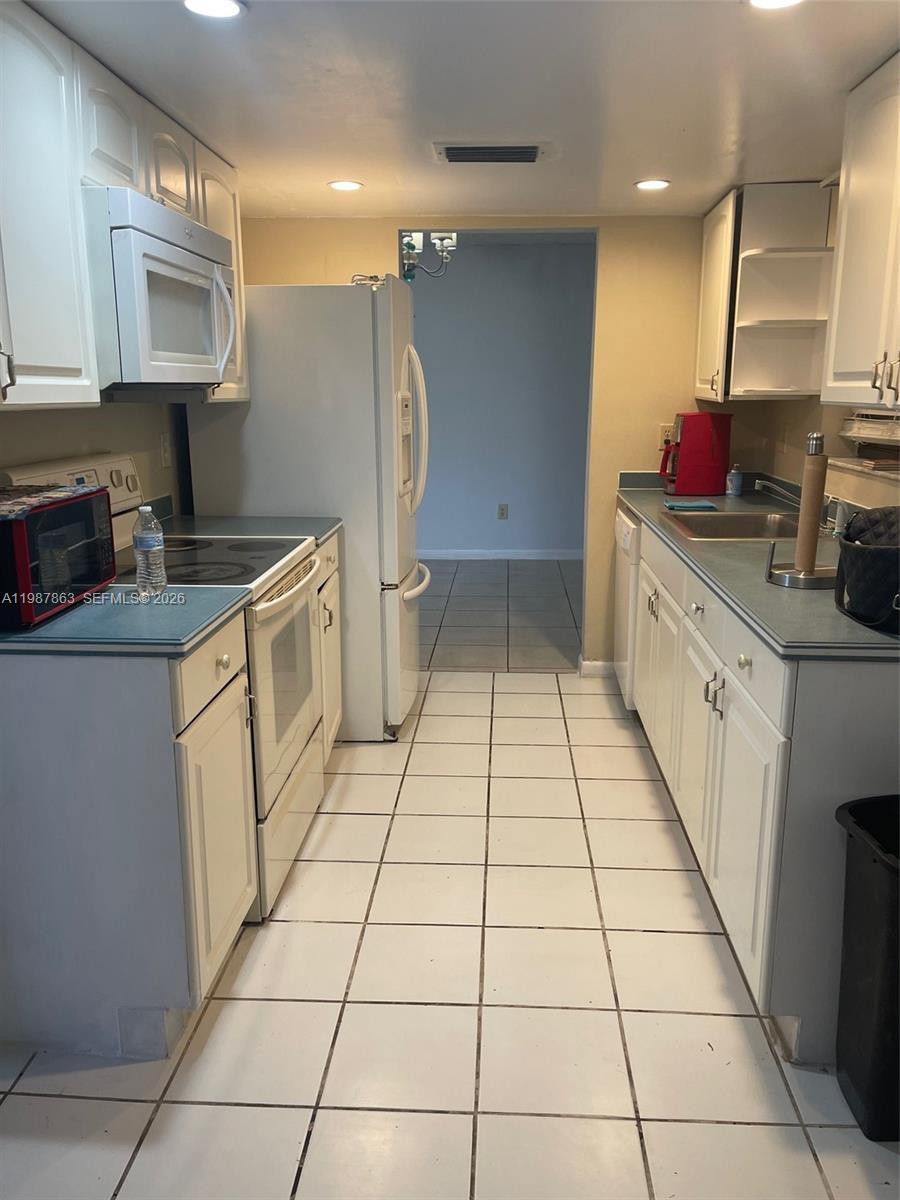 1419 Yellowthroat Street Homestead, FL 33035 - Photo 18 of 26 a kitchen with stainless steel appliances a sink stove and cabinets