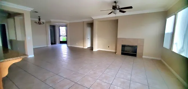 an empty room with windows and fireplace