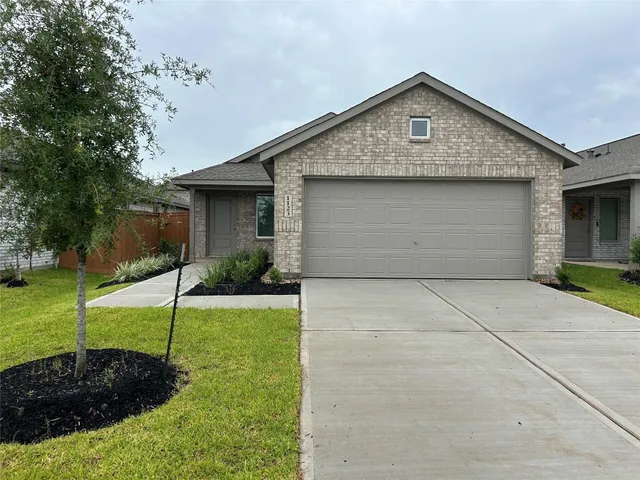 a front view of a house with a yard and a garage