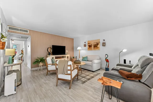 a living room with furniture wooden floor and a flat screen tv