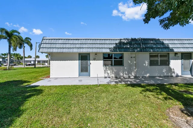 a front view of a house with a yard garden and outdoor seating