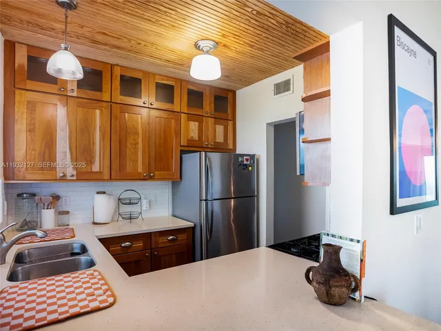 a kitchen with a refrigerator a sink and cabinets