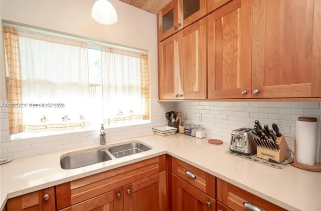 a kitchen with a sink a window and cabinets