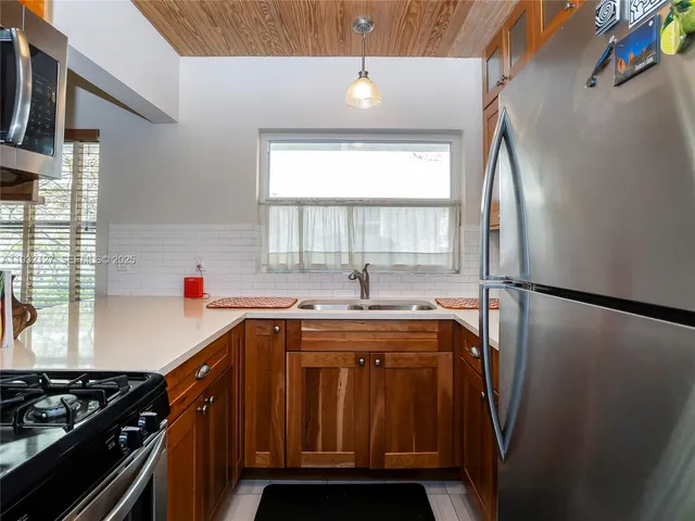 a kitchen with stainless steel appliances a sink stove and refrigerator