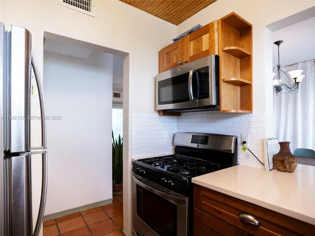 a kitchen with stainless steel appliances a stove a microwave and a refrigerator
