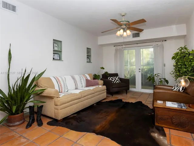 a living room with furniture and a potted plant