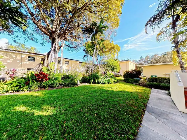 a view of a house with a big yard and potted plants