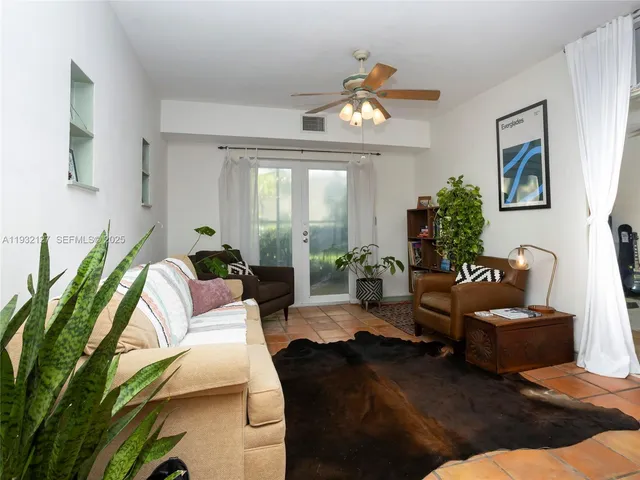 a living room with furniture potted plant and a window