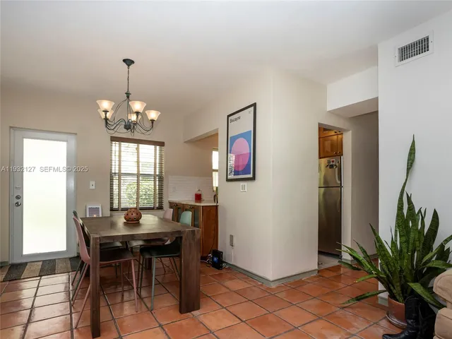 a dining room with furniture potted plants and wooden floor