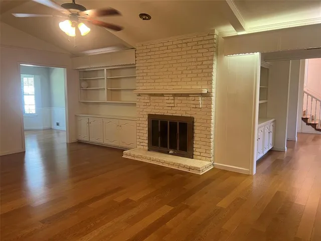 a view of a livingroom with wooden floor a fireplace and window