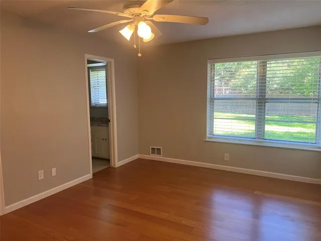 a view of a kitchen with a fridge and wooden floor