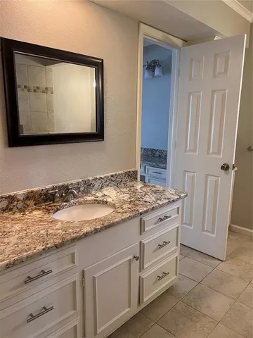 a bathroom with a granite countertop sink a toilet and a mirror