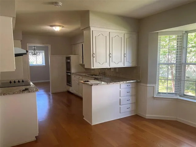 a kitchen with granite countertop white cabinets and white appliances