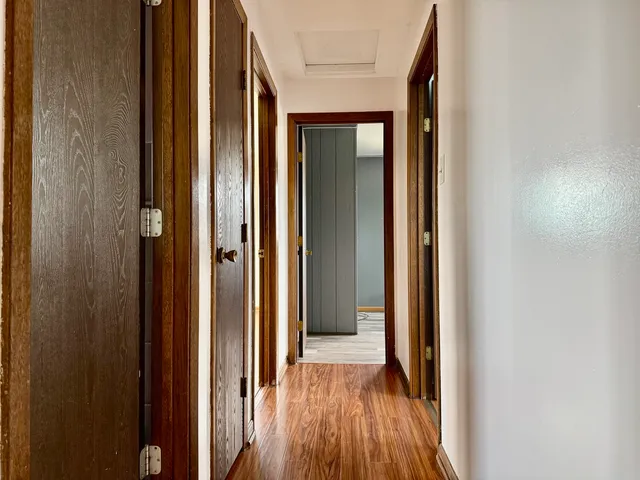 a view of a hallway with wooden floor