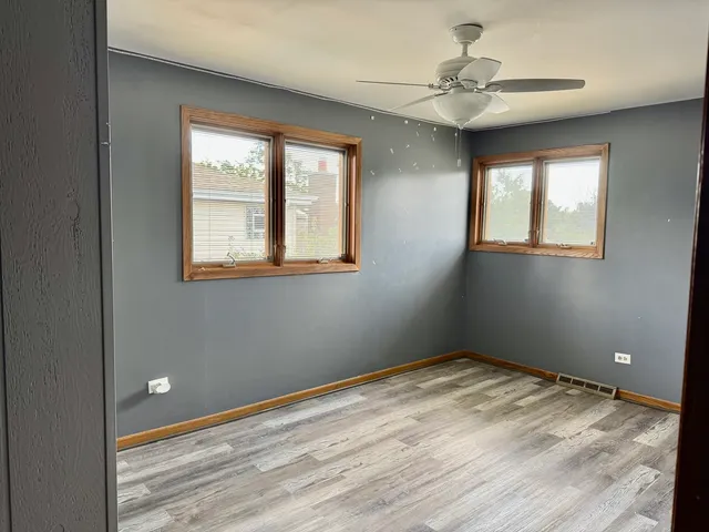 a view of empty room with window and ceiling fan