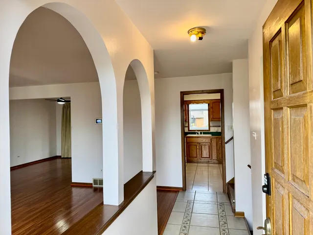a view of a hallway with wooden floor and staircase