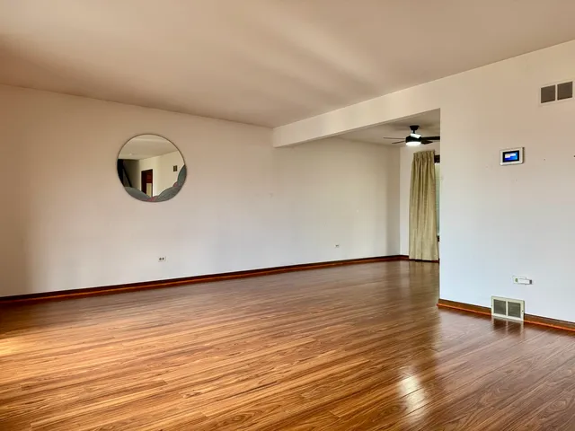 a view of an empty room with wooden floor