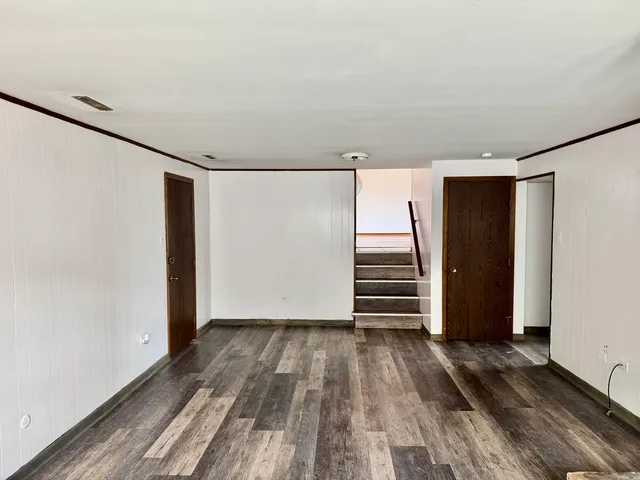 a view of empty room with wooden floor