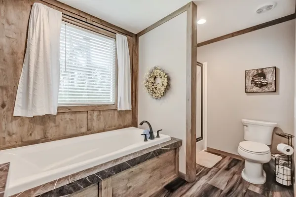 a bathroom with a granite countertop sink and a bathtub