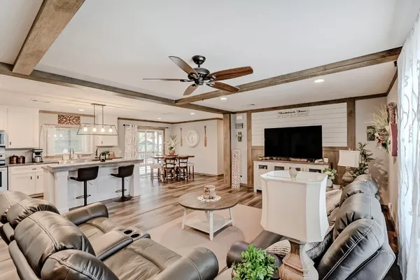 a living room with furniture a flat screen tv and a clock