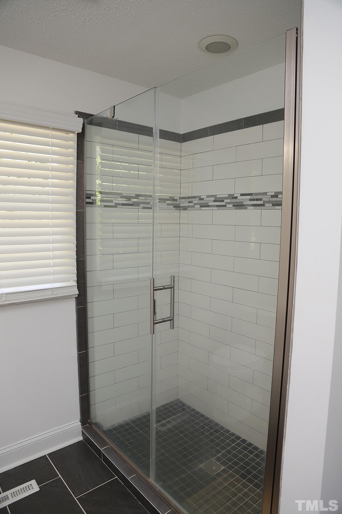 3712 Pleasant Valley Road Raleigh, NC 27613 - Photo 22 of 32 a bathroom with a glass shower door