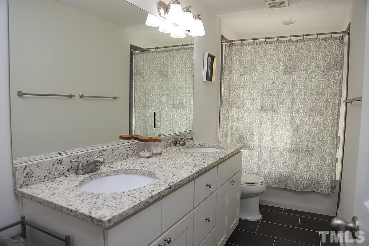3712 Pleasant Valley Road Raleigh, NC 27613 - Photo 24 of 32 a bathroom with a granite countertop sink and a mirror