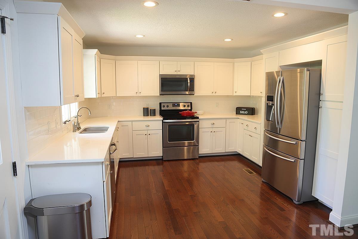 3712 Pleasant Valley Road Raleigh, NC 27613 - Photo 10 of 32 a kitchen with a sink stainless steel appliances and wooden floor