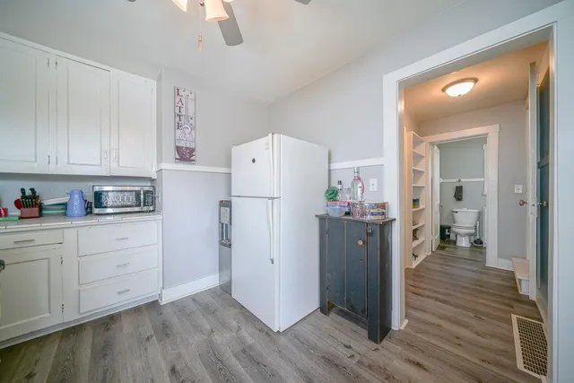 a kitchen with a refrigerator a stove and wooden floor