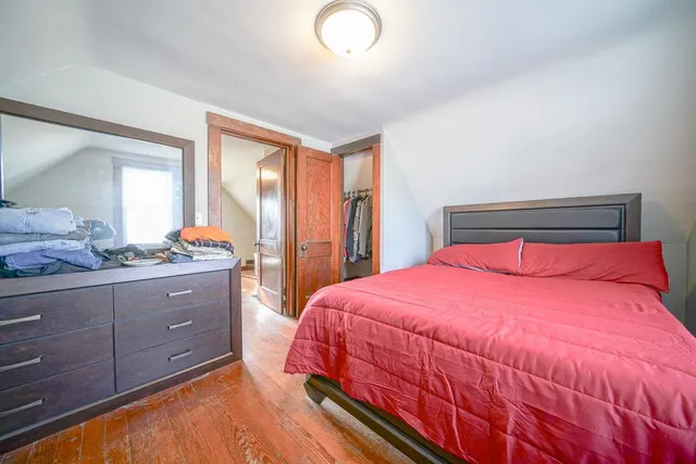 a bedroom with a bed and wooden floor