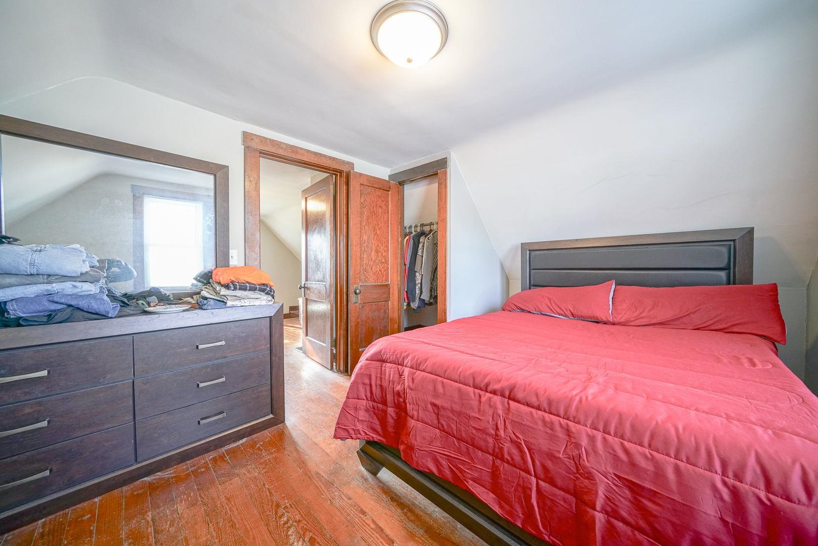 409 West Lincoln Street Mount Morris, IL 61054 - Photo 15 of 28 a bedroom with a bed and wooden floor