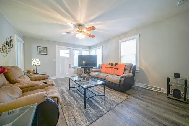 a living room with furniture and a wooden floor
