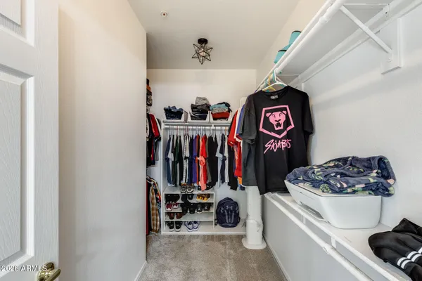 a view of walk in closet with clothes and shoes