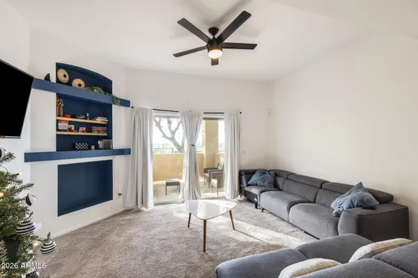 a living room with furniture a flat screen tv and a fireplace
