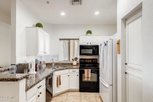 a kitchen with stainless steel appliances granite countertop a stove sink and cabinets
