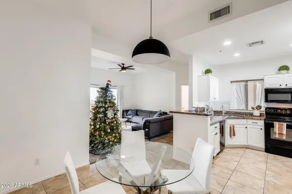 a kitchen with stainless steel appliances granite countertop a stove a sink a dining table and chairs